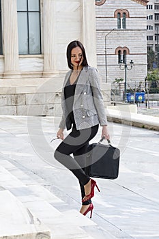 Happy woman climbs marble stairs