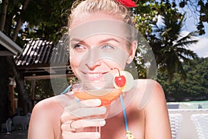 Happy woman with cocktail at the beach restaurant