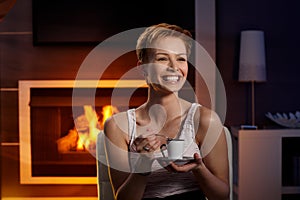 Happy woman with coffee in cosy room