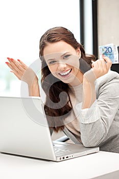 Happy woman with computer and euro cash money