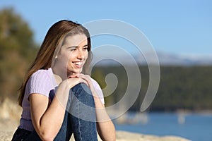 Happy woman contemplating views in a beautiful lake