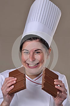 Happy woman cook dividing and holding chocolate