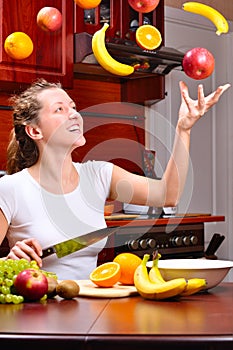 Happy woman is cooking fruit salad