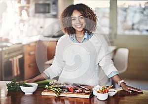 Happy woman cooking healthy food from diet meal plan on home kitchen table for wellness lifestyle. Beautiful, confident