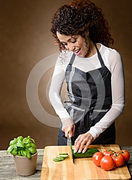 Happy Woman Cooking. Healthy Food - Fresh cucumber