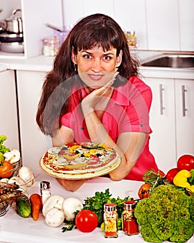 Happy woman cooking pizza.
