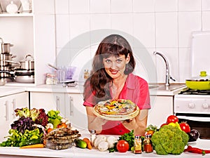Happy woman cooking pizza.