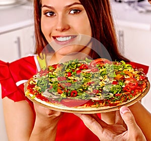 Happy woman cooking pizza