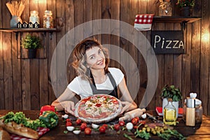 Happy woman cooking pizza at home kitchen.