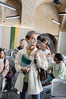 happy woman with copybooks looking away