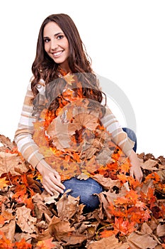 Happy woman covered with autumn leaves