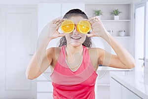 Happy woman covers her eyes with orange