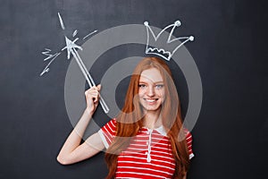 Happy woman with crown and magic drawn on blackboard background