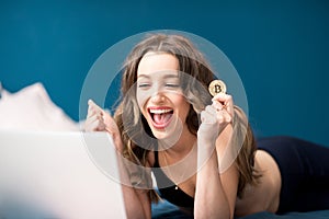 Happy woman with crypto coin at home