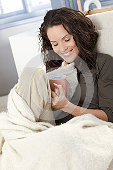 Happy woman cuddling with blanket