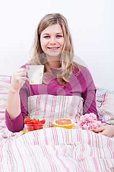 Happy woman with cup of coffee and breakfast