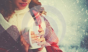 Happy woman with cup of hot drink on cold winter outdoors