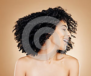 Happy woman, curly and hair shake afro for fun on studio background in healthy hairstyle growth, texture or frizz