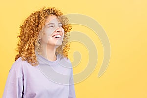 A happy woman with curly hair standing