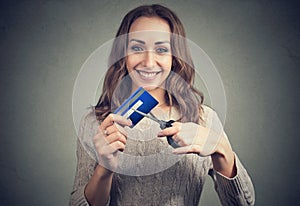 Happy woman cutting credit card