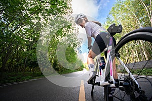 happy woman cycling athlete prepare for ride bicycle on street for exercise