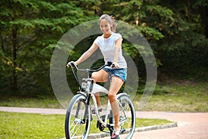 Happy Woman is Cycling in Summer Park