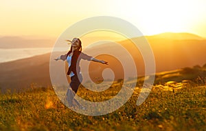 Happy woman dances, rejoices, laughs on sunset in nature photo