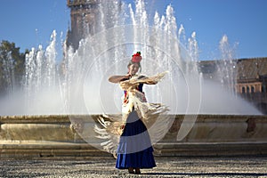 The happy woman dancing in front of the fountain photo