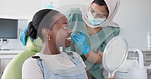 Happy woman, dentist and patient with mirror for dental care, teeth cleaning or treatment at clinic. Young female person