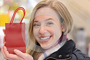 Happy woman displaying a small Christmas gift