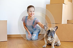 Happy woman with dog and boxes moving to new home