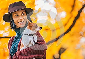 Happy woman with dog outdoors in autumn lookin