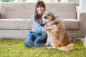 The happy woman dog owner at home with golden retriever