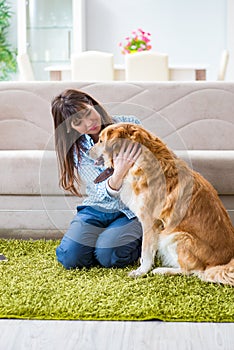 The happy woman dog owner at home with golden retriever