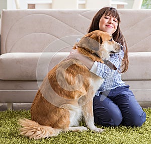 Happy woman dog owner at home with golden retriever