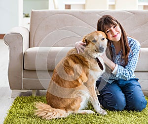 Happy woman dog owner at home with golden retriever