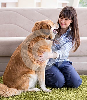 Happy woman dog owner at home with golden retriever