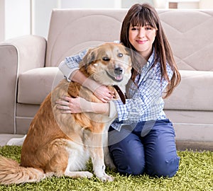 Happy woman dog owner at home with golden retriever