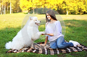 Happy woman and dog resting in the park