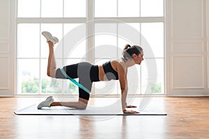 Happy Woman Doing Donkey Kicks Exercise With Resistance Band