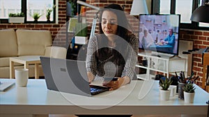 Happy woman doing online shopping, typing credit card information on laptop