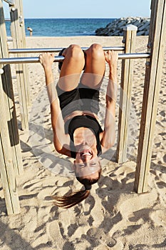 Happy woman doing sport exercises on the beach. Vertical headshot. photo