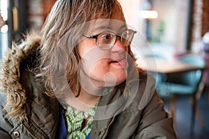 Happy woman with the Down Syndrome looking away, indoor portrait, Tienen, Belgium photo