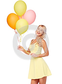 Happy woman in dress with helium air balloons