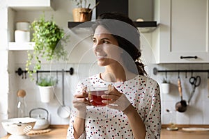 Happy woman drink tea at home dreaming