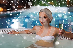 Happy woman drinking champagne at swimming pool