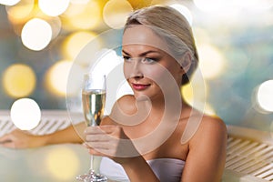 Happy woman drinking champagne at swimming pool