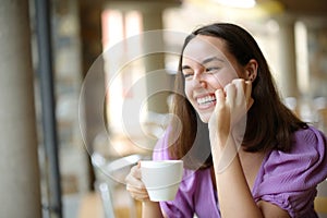 Happy woman drinking coffee contemplating in terrace