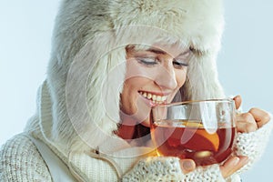 Happy woman drinking cup of hot tea with lemon and honey