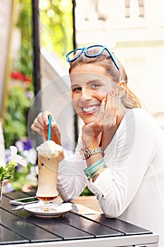 Happy woman drinking frappe in cafe photo
